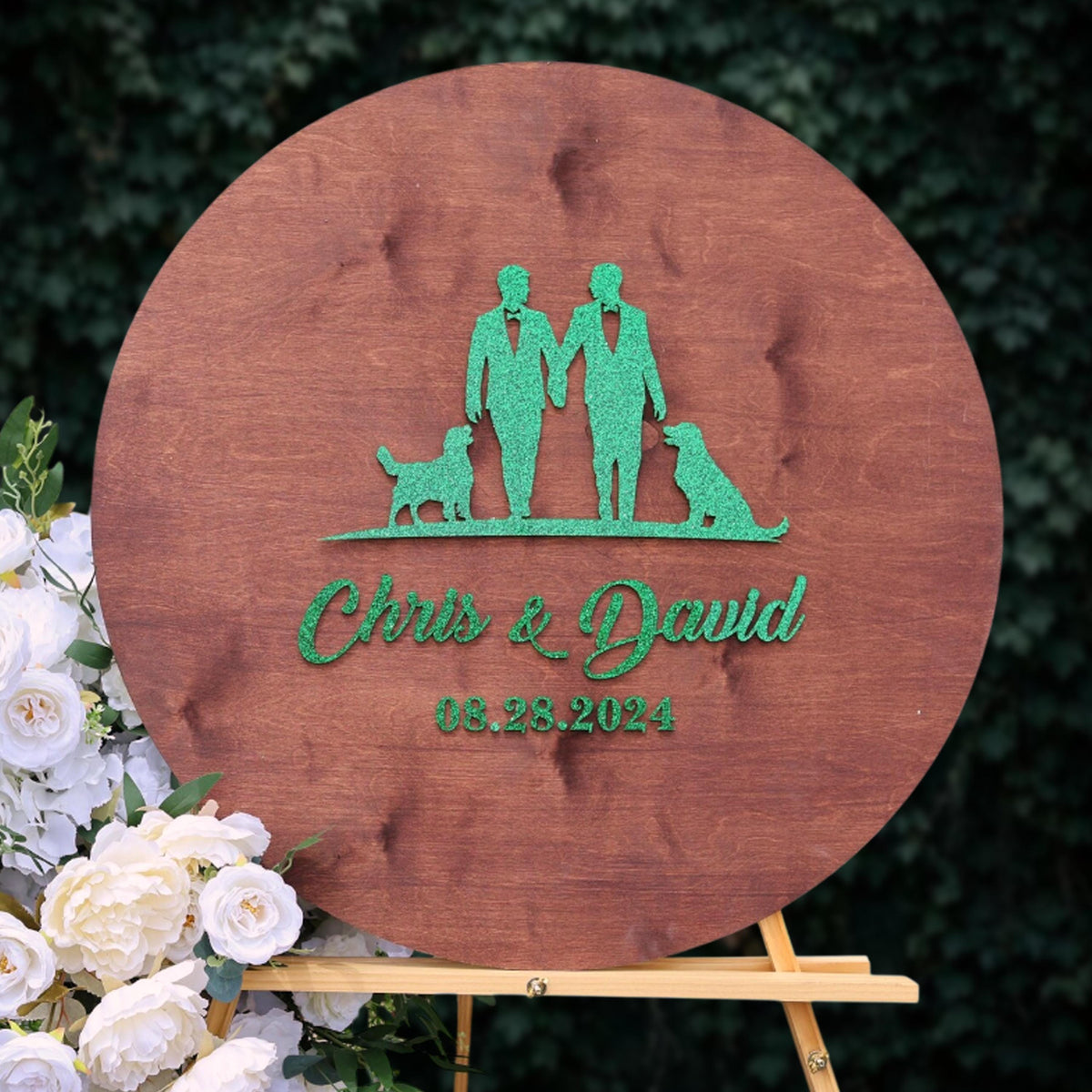 A wooden sign with a green silhouette of two people holding hands and a dog, along with the text "Chris & David" and the date "08.28.2024".