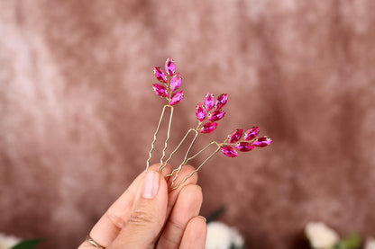 a person holding a pink flower in their hand