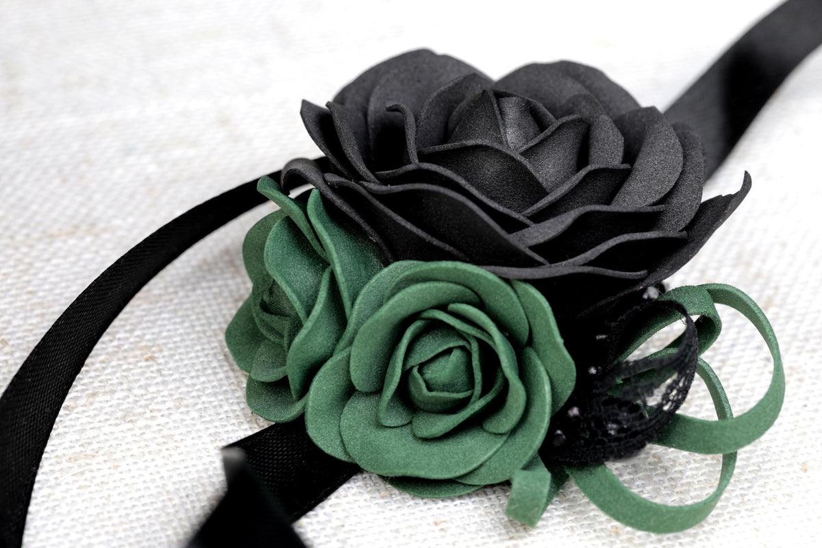 a black and green flower on a black ribbon