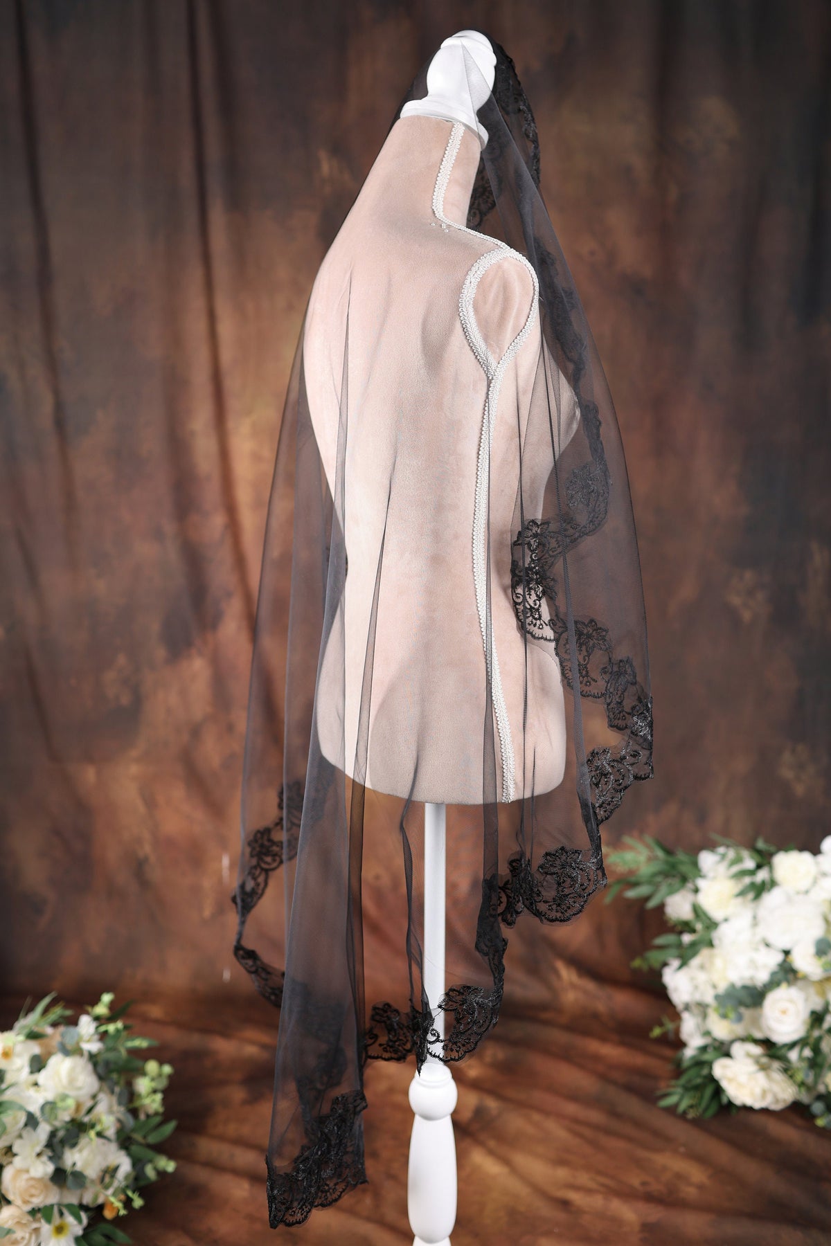a white mannequin with a black veil on top of it