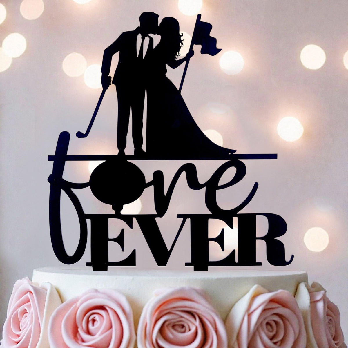 A silhouette of a bride and groom holding a flag on top of a cake with the words "love ever" written on it.