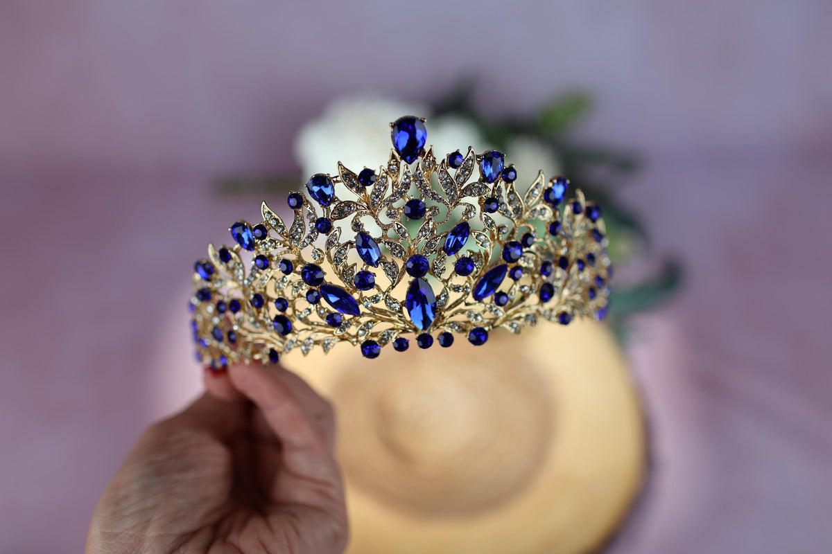 a person holding a piece of jewelry next to a flower