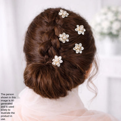 a woman's back with her hair styled in a bun, adorned with small white flower-shaped hair clips.