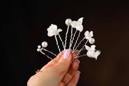 a hand holding a bunch of white flowers
