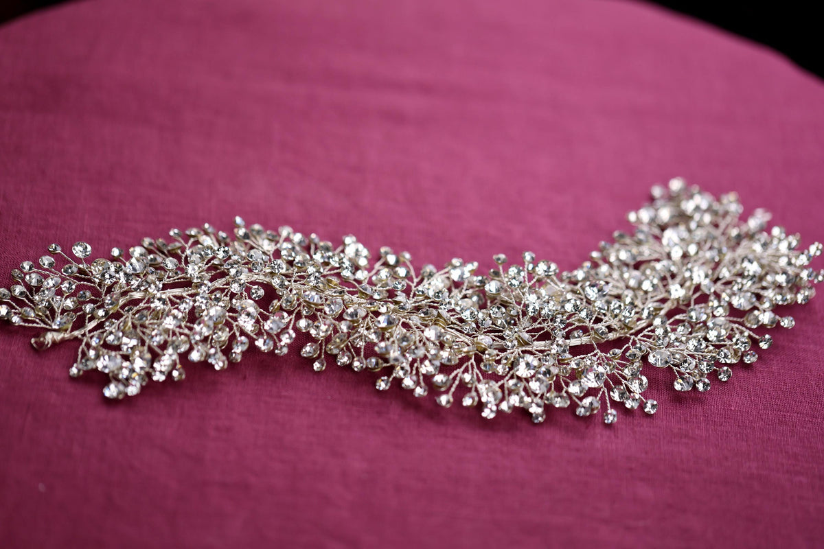 a close up of a piece of jewelry on a pink surface