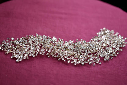a close up of a piece of jewelry on a pink surface