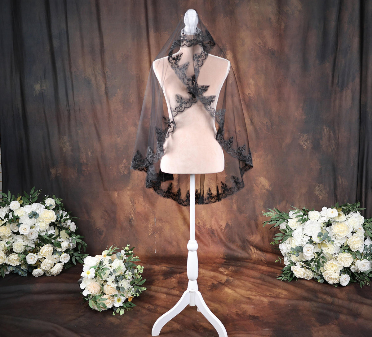 a white mannequin with a black veil on top of it