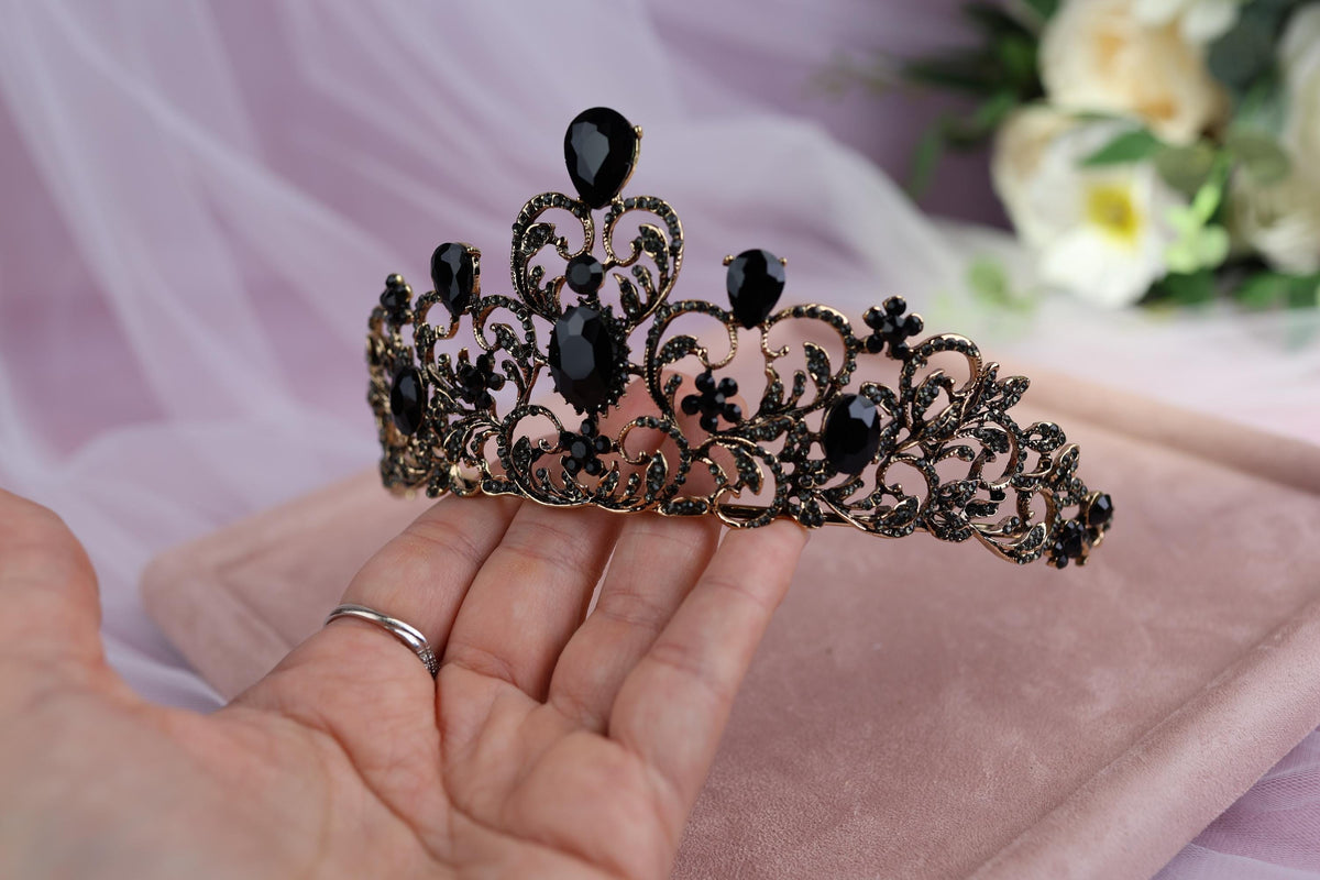 a woman is holding a tiara in her hand