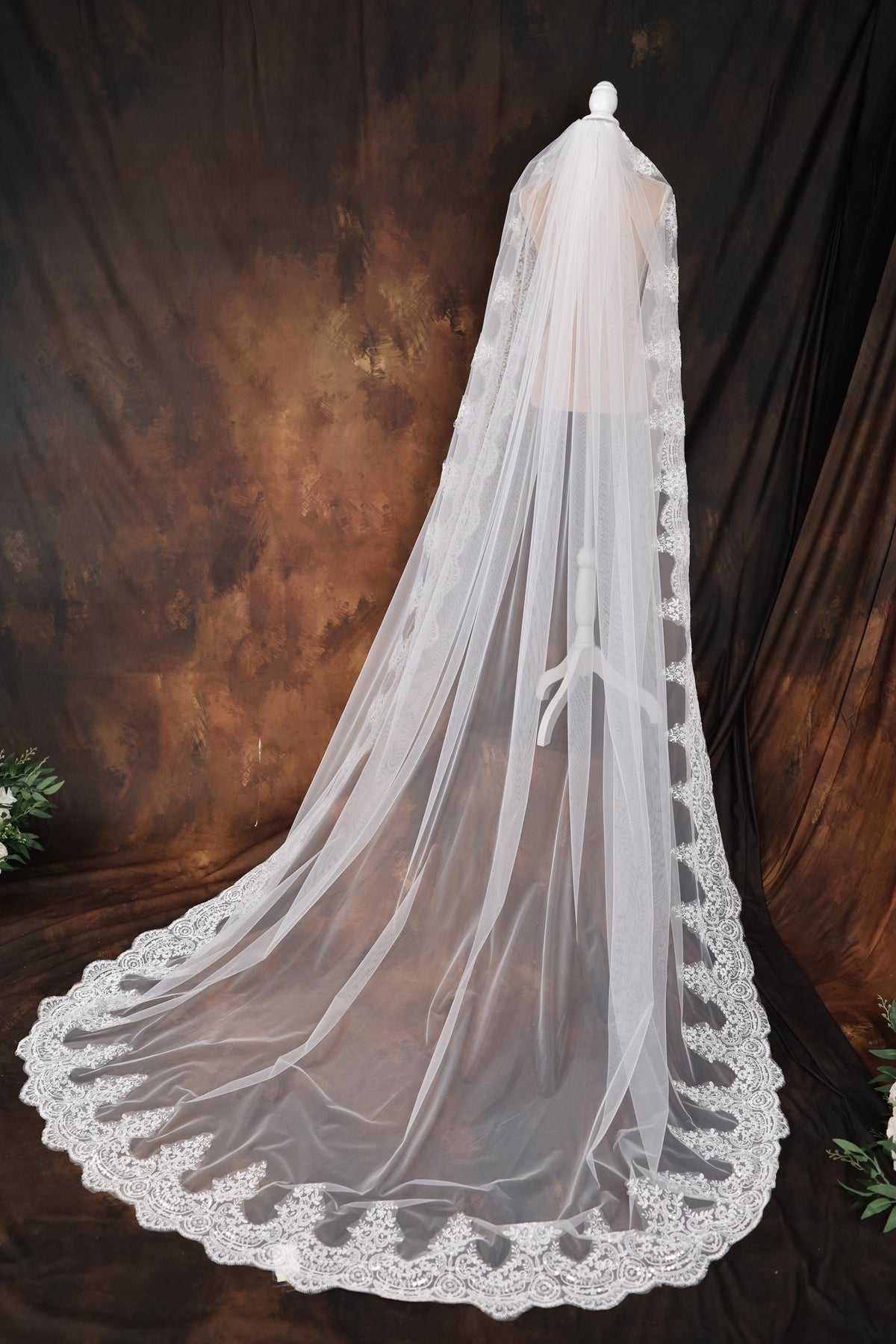 a white wedding veil with a bow on top of it
