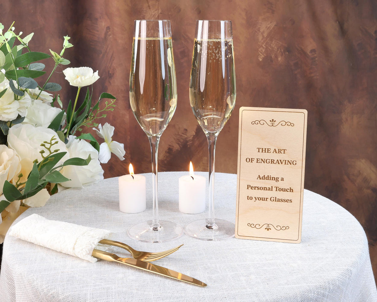 a table topped with two wine glasses and a sign