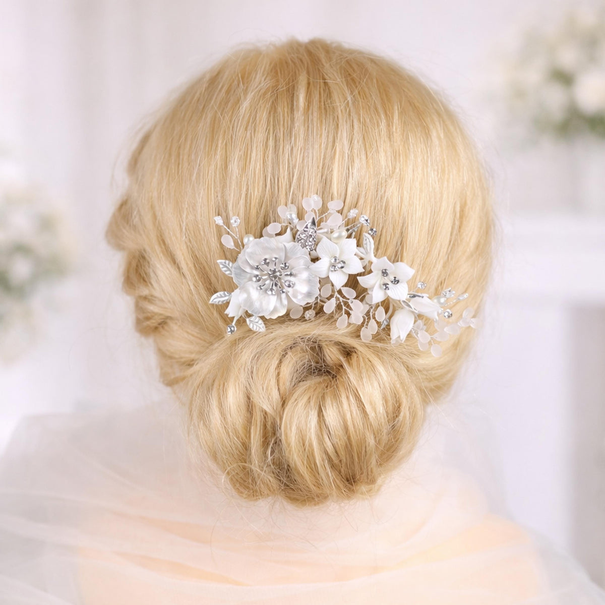 A close-up of a woman's blonde hair with a decorative hair accessory featuring white flowers.