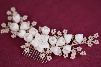 a hair comb with flowers and pearls on it
