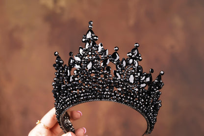 a hand holding a black and white tiara