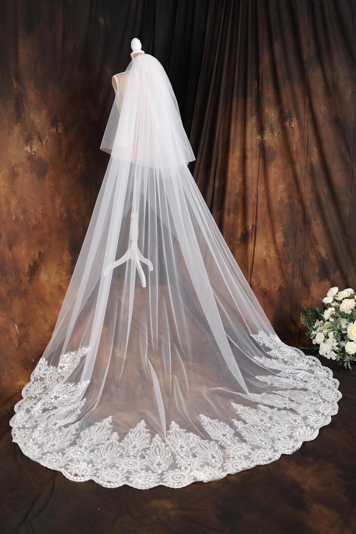 a wedding veil on a mannequin in front of a backdrop