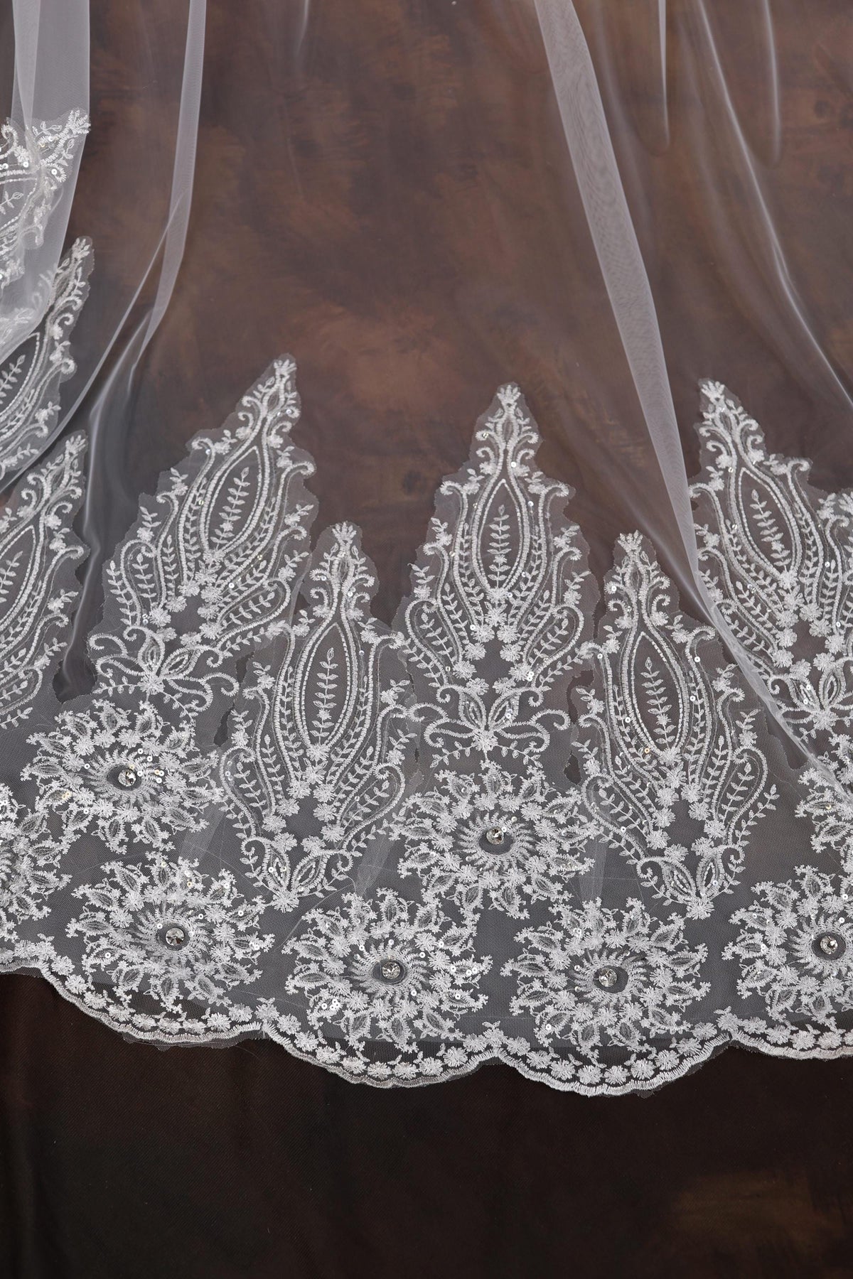 a close up of a white lace on a brown background