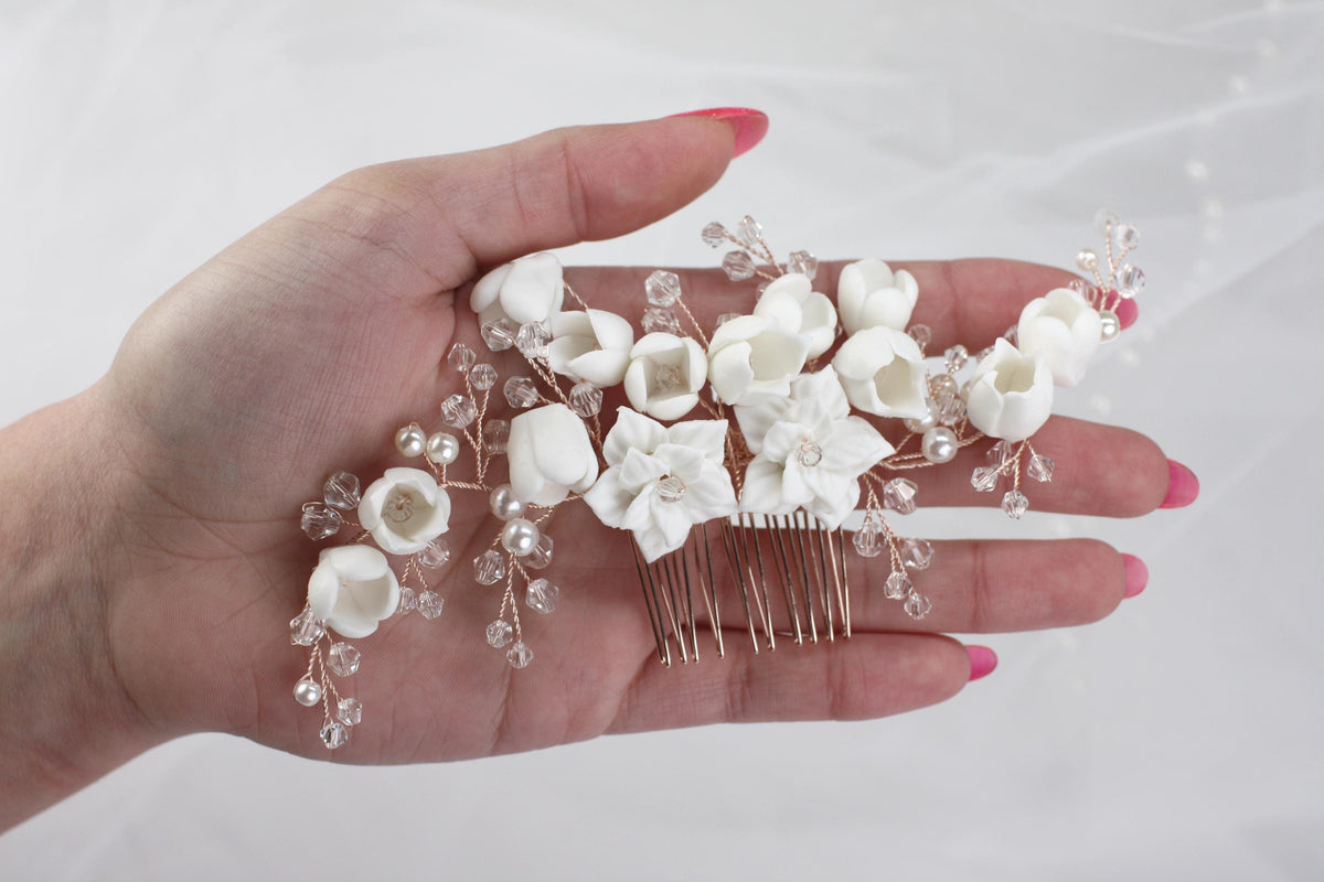 a woman's hand holding a hair comb with flowers on it