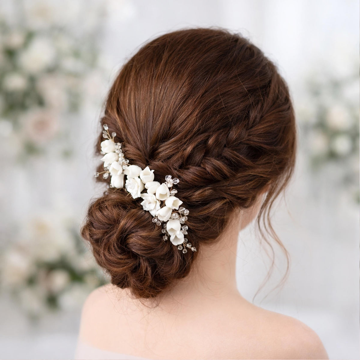 a woman's back view with her hair styled in an updo, adorned with a decorative flower accessory.