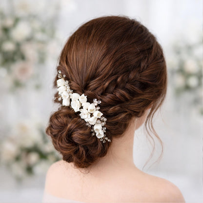 a woman's back view with her hair styled in an updo, adorned with a decorative flower accessory.