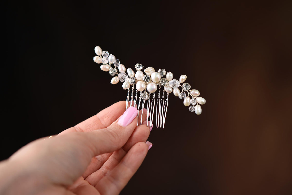 a woman holding a hair comb with pearls on it