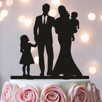 A silhouette of a family, including a man, a woman, and a child, is displayed on top of a cake.