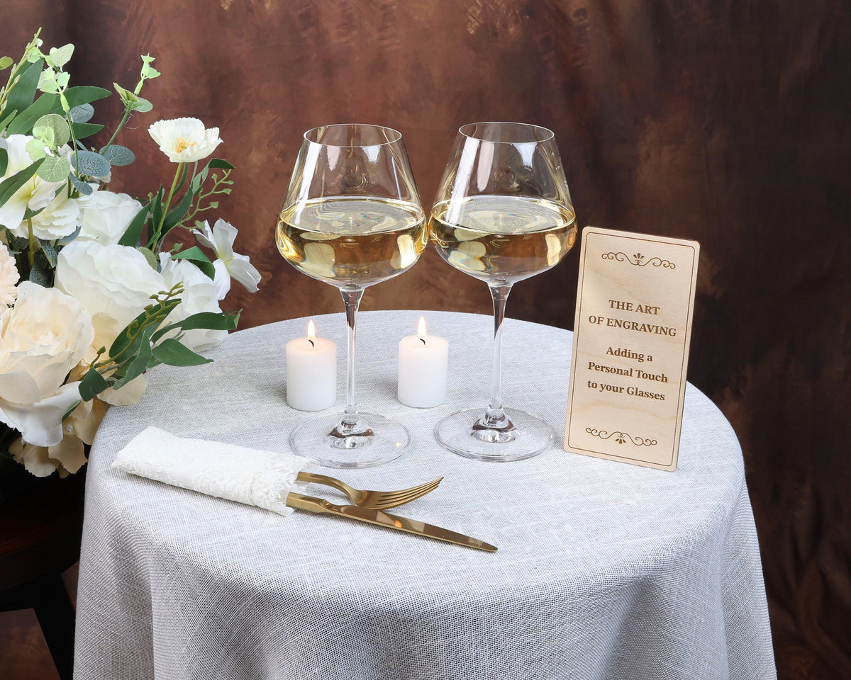two glasses of wine on a table with a sign