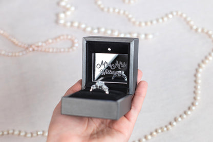 a person holding a ring in a box