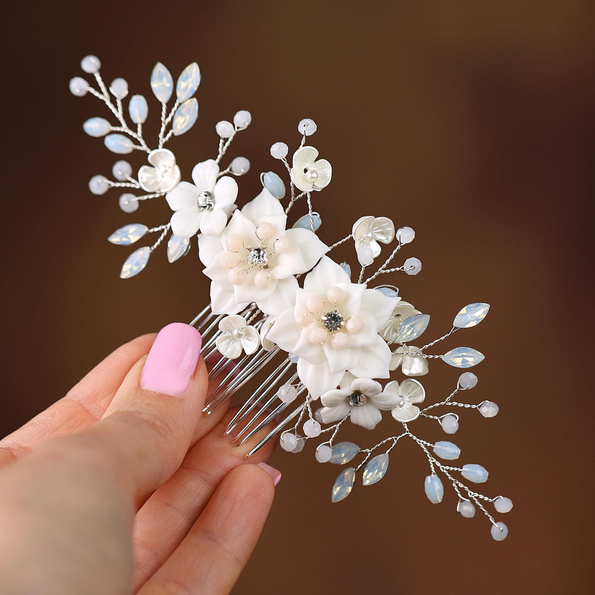 a hand holding a hair comb with flowers on it