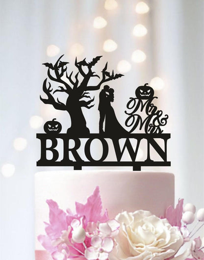 A black silhouette of a bride and groom on a cake topper, with the word "BROWN" below it.