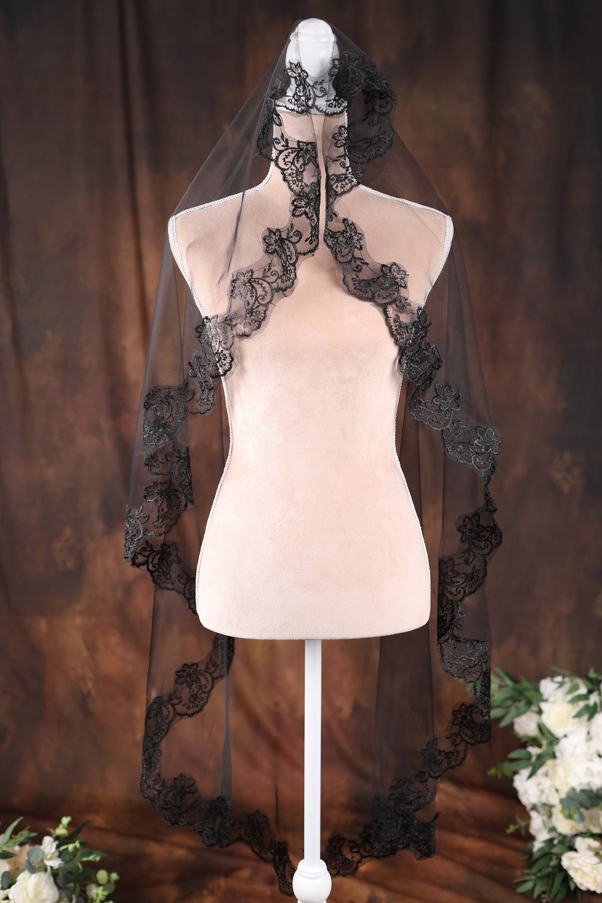 a white mannequin with a black veil on top of it
