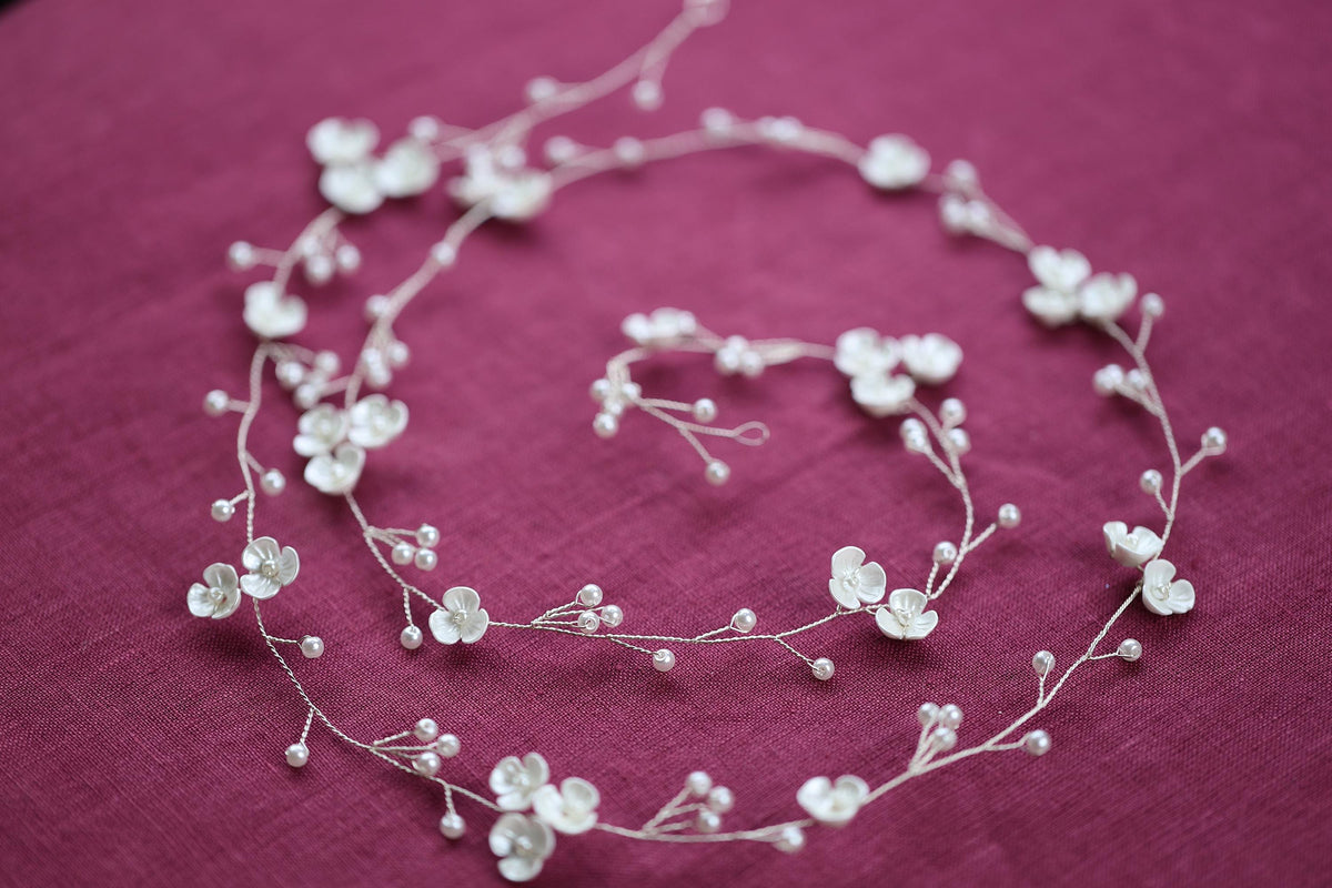 a close up of a necklace with flowers on it