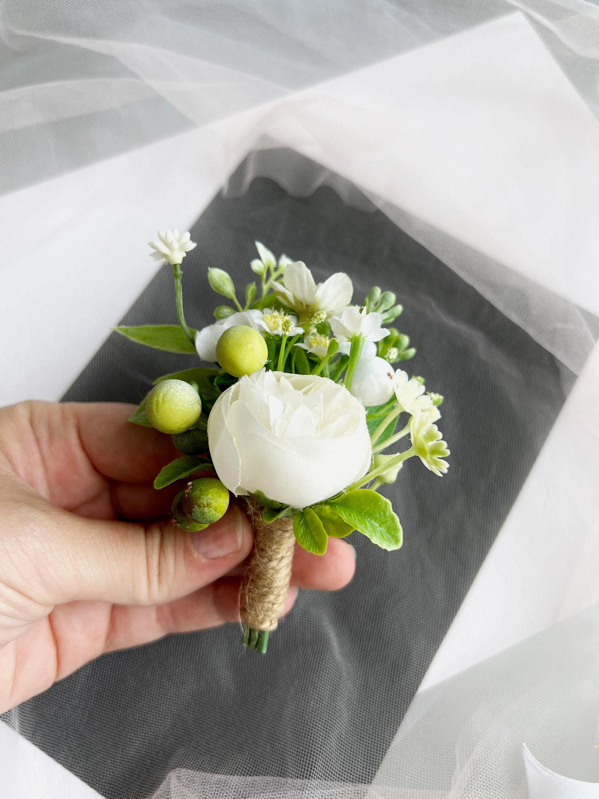 a person holding a white flower in their hand