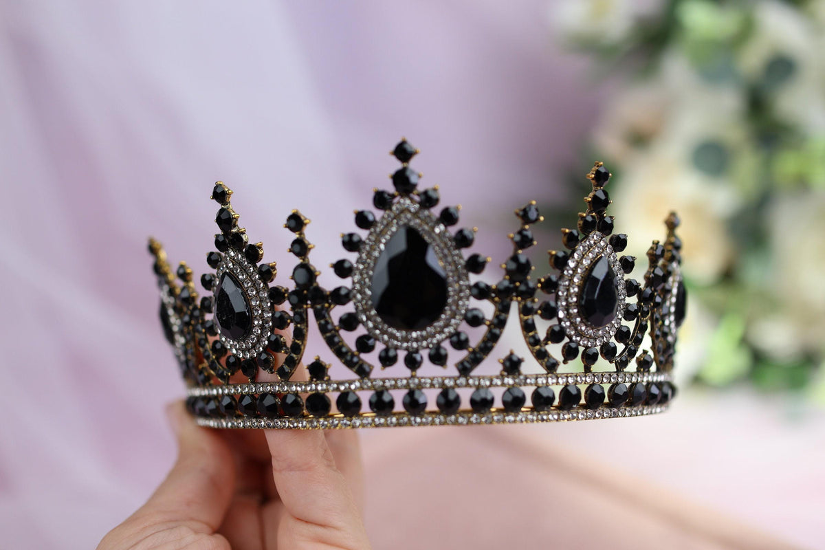 a hand holding a black and white tiara