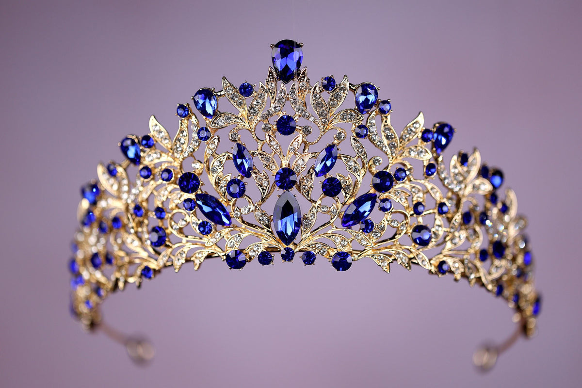 a blue and gold tiara on a purple background