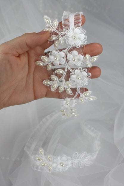 a hand holding a wedding hair comb with flowers on it
