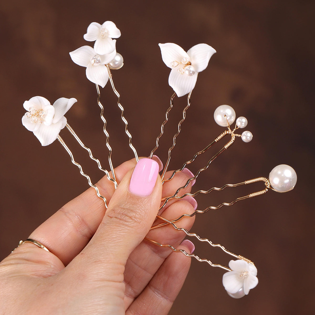 a hand holding a bunch of white flowers