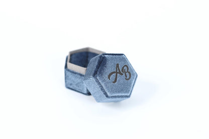 A blue hexagonal box with a logo on it, placed on a white background.