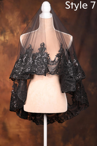 A mannequin wearing a black lace veil with intricate floral patterns, displayed against a brown background.