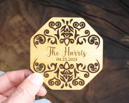 a person holding a wooden coaster with a name on it