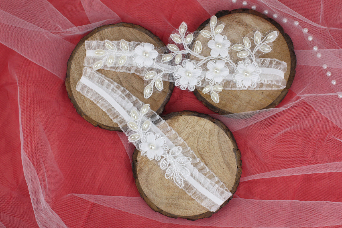 a pair of wooden shoes with white lace and flowers on them