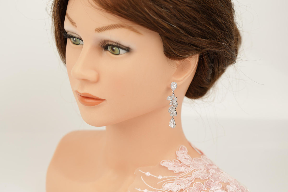 A close-up of a mannequin head wearing a pair of diamond earrings.