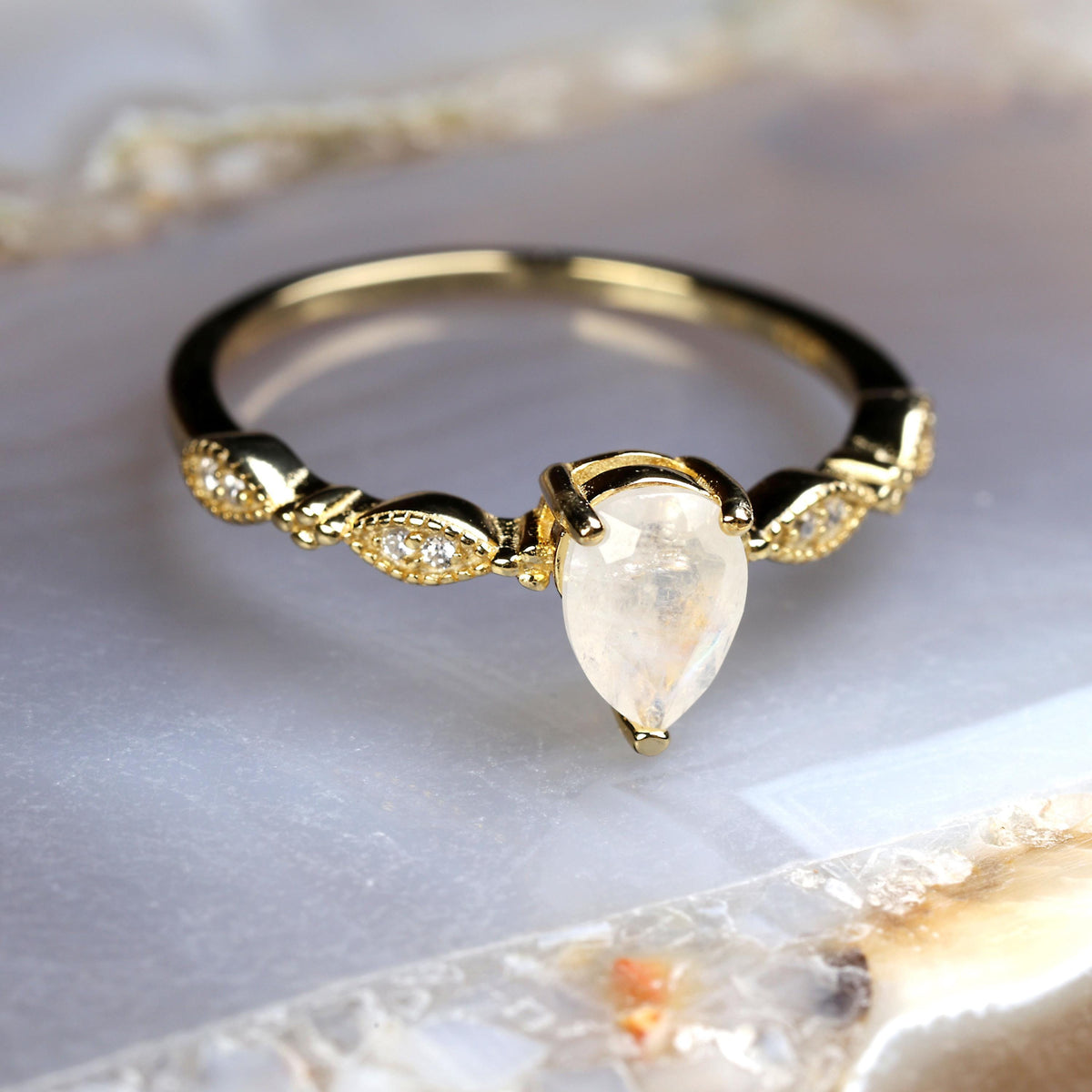 a gold ring with a pear shaped diamond