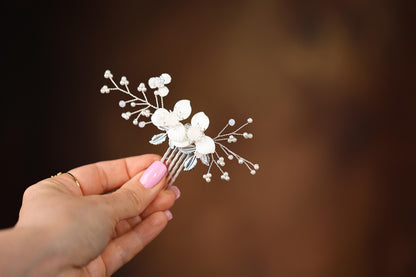 a woman holding a white flower hair comb
