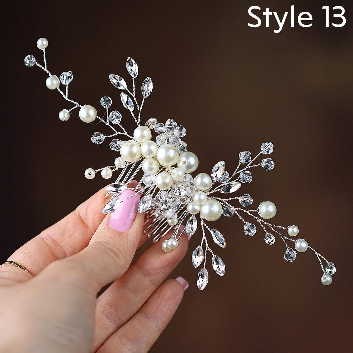 a hand holding a hair comb with pearls and leaves