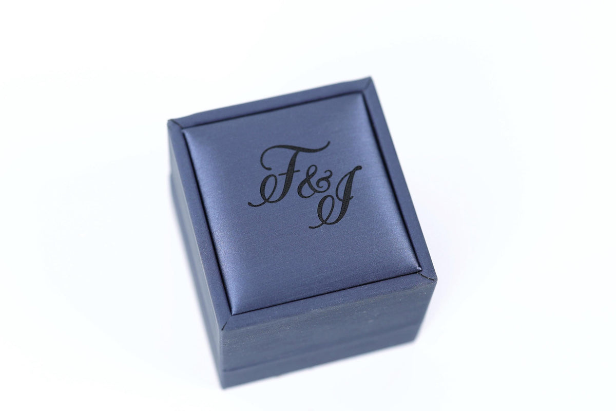 A blue jewelry box with the text "F&J" printed on it.