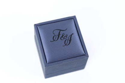 A blue jewelry box with the text "F&J" printed on it.