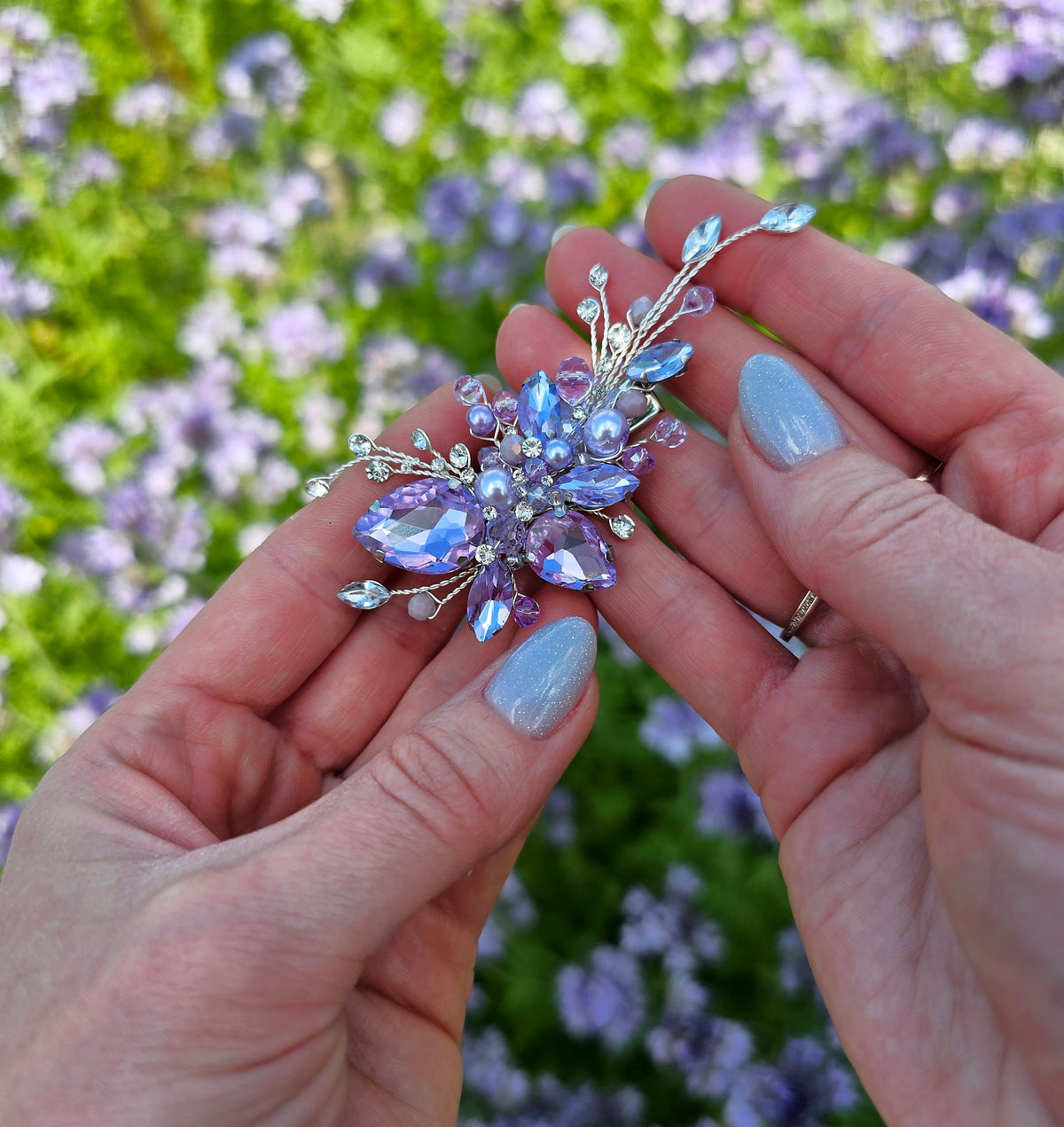 a person holding a flower shaped brooch in their hands