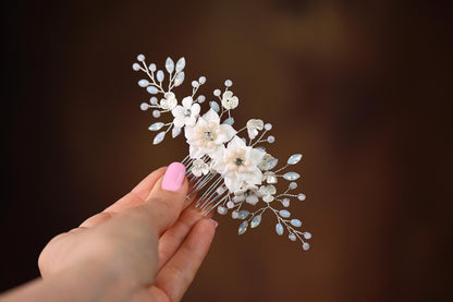 a hand holding a hair comb with flowers on it