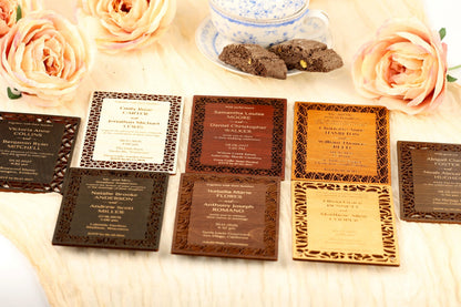 A collection of wedding invitations with various designs and colors, including brown, black, and wooden frames, arranged on a table with pink roses and a teacup.