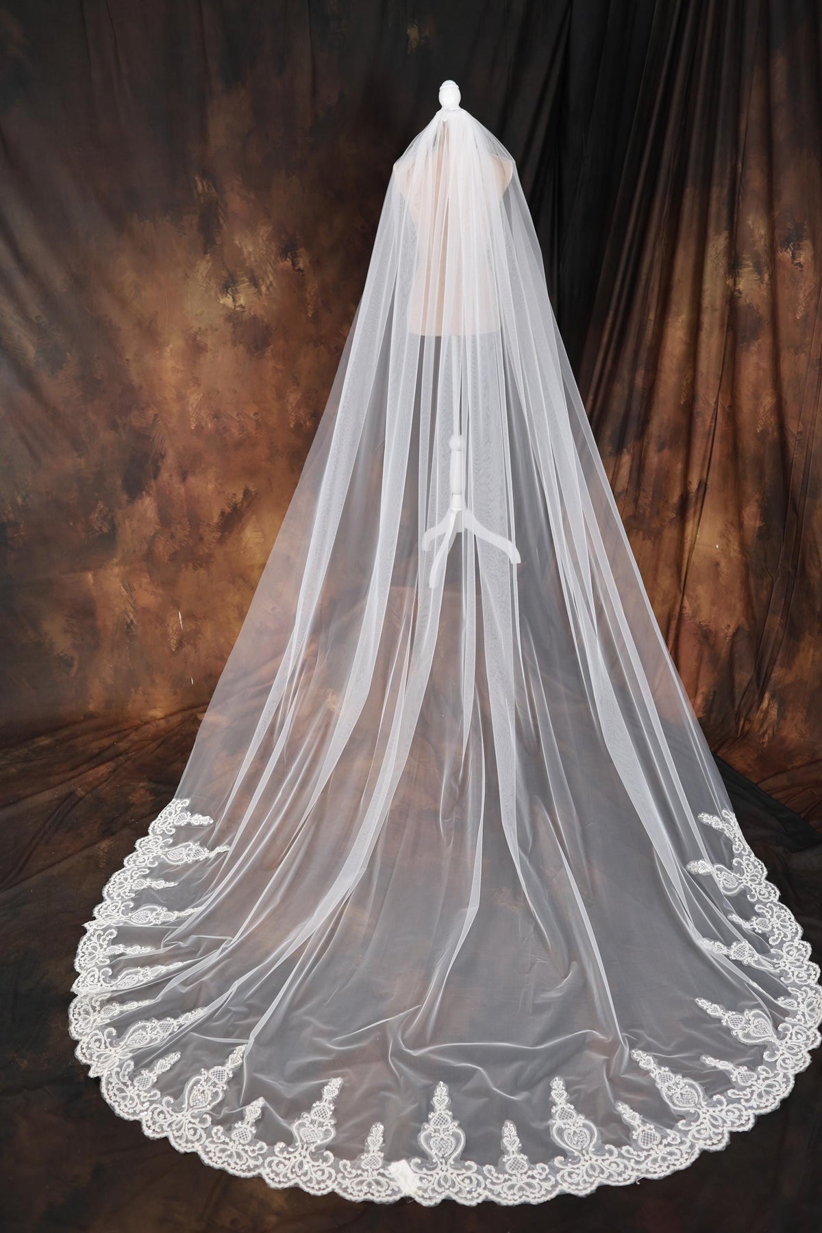 a wedding veil with a lace edge on a mannequin