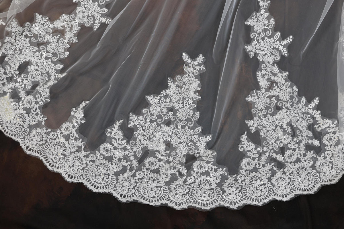 a close up of a wedding veil with flowers on it